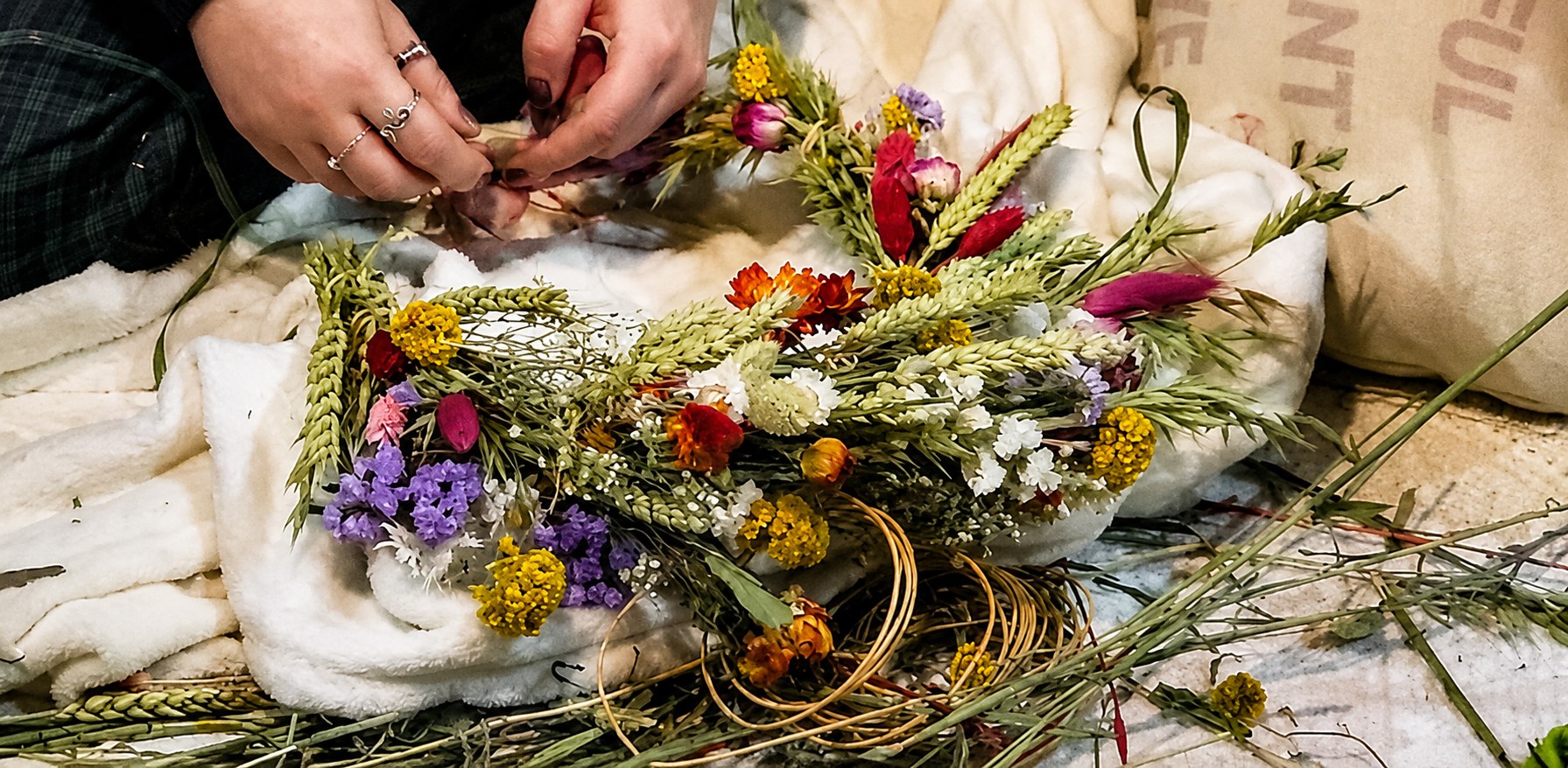 Hands making a seasonal wreath at The Wenlock Witch